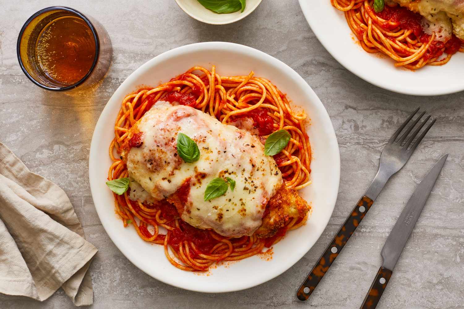 Chicken in a red sauce with mozzarella cheese over pasta